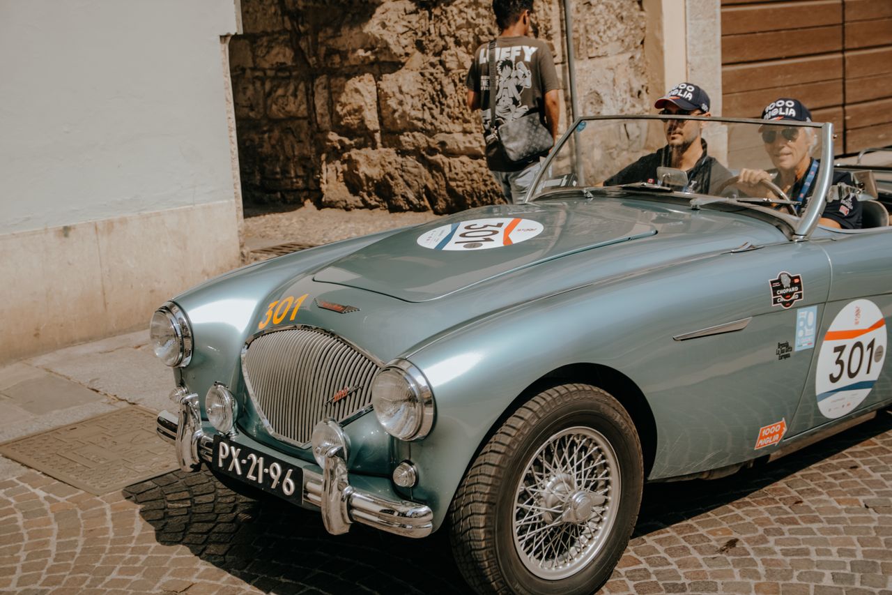 Classic vintage car participating in a rally on an urban street in Brescia, Italy.