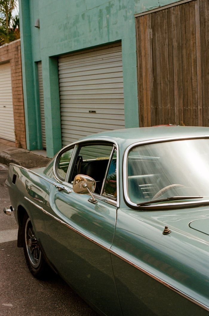 Vintage clean sparkling automobile with shiny windows parked near shabby building on street in summer